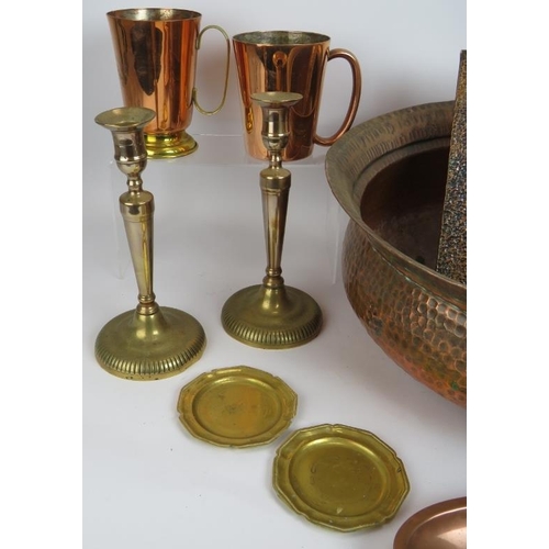 248 - Mixed copper and brassware including a large planished bowl, a heavy antique kettle, two mugs, dishe... 