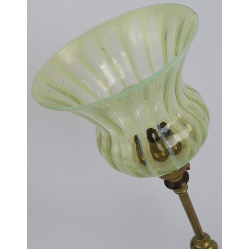 285 - A brass Arts & Crafts desk lamp with adjustable arm, standing on lion paw feet and with a green Vase... 