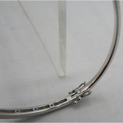 416 - An 18ct white gold bangle with one half set with a band of diamonds. Diamonds approx 1ct, double cli... 