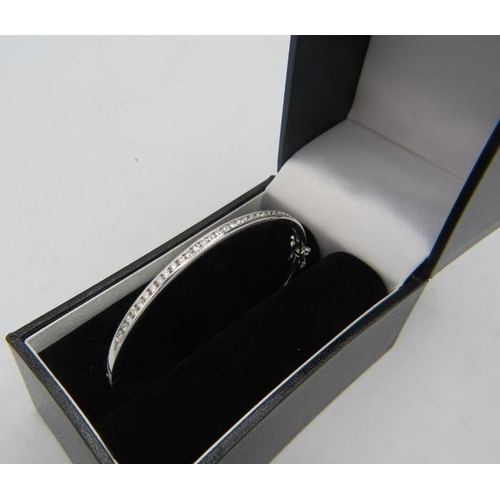 416 - An 18ct white gold bangle with one half set with a band of diamonds. Diamonds approx 1ct, double cli... 