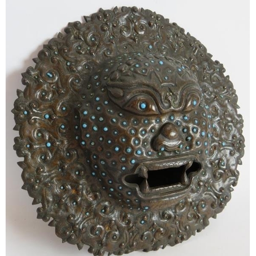 45 - An antique bronze Indian temple mask inset with small blue stones. Believed to be used for warding o... 