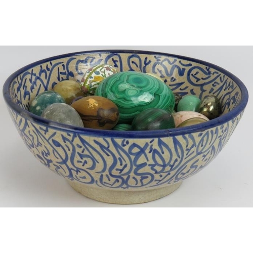 62 - A blue and white Islamic pottery bowl containing a collection mainly semi precious stone eggs includ... 