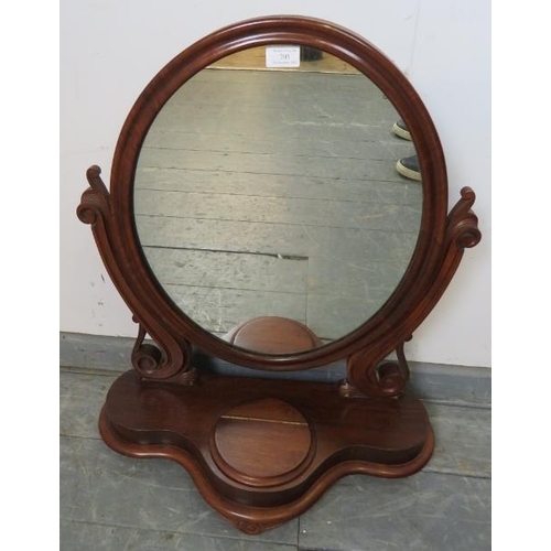 705 - A Victorian mahogany oval swing vanity mirror, with scrolled and pierced uprights, on a shaped plint... 