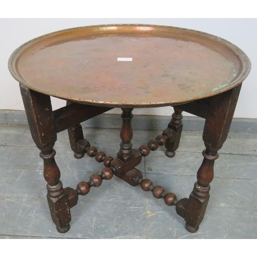 715 - A 19th century Arts & Crafts copper tray table by Hugh Wallis, on a turned and block folding oak sta... 