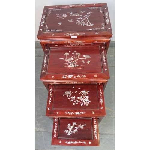 724 - A vintage Chinese hardwood quartetto of nesting tables, featuring mother of pearl inlay depicting so... 