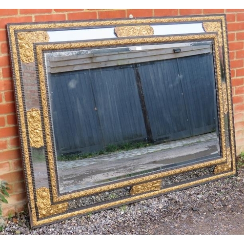 734 - A large 19th century Napoleon III ebonised cushion mirror, the sectioned bevelled glass featuring or... 