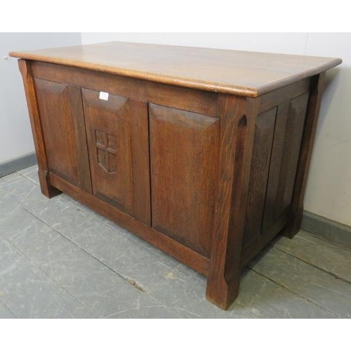 741 - An Arts & Crafts oak coffer with fielded panels to all four sides and a relief carved shield to cent... 