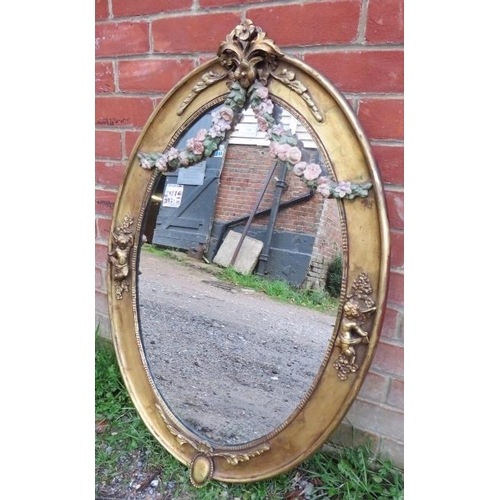 749 - A 19th century oval wall mirror in an ornate gilt gesso frame featuring polychrome decoration in the... 