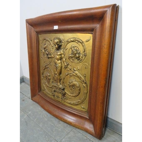 750 - A Rococo embossed gilt brass panel depicting a cherub holding compasses and quill, mounted in an oak... 