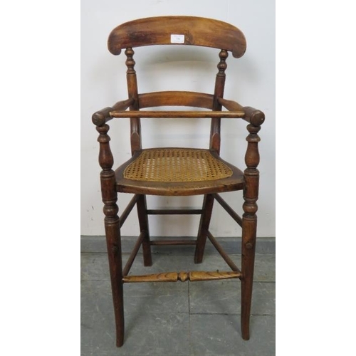 756 - An Edwardian oak child’s highchair with bergère seat, on turned supports with stretchers. 
Condition... 