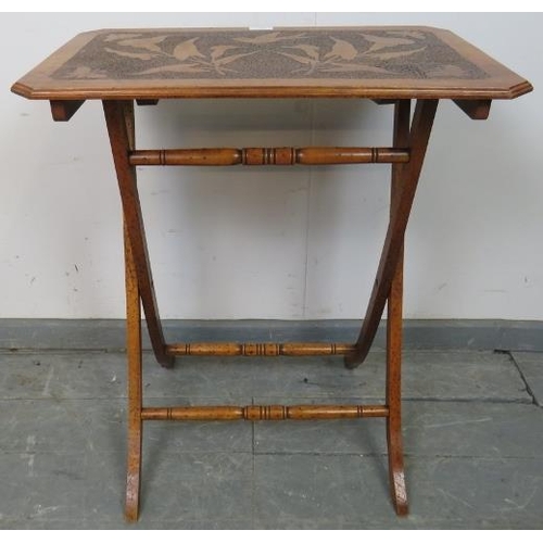 757 - An Arts & Crafts walnut folding side table with pokerwork top depicting flora and fauna, on X frame ... 