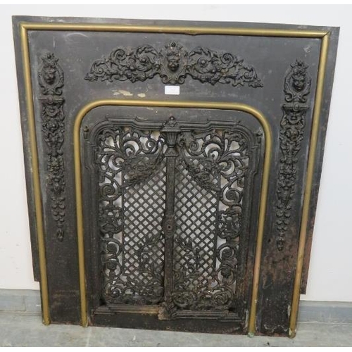 762 - An antique cast iron and brass fireplace insert, the applied decoration depicting scrolling acanthus... 