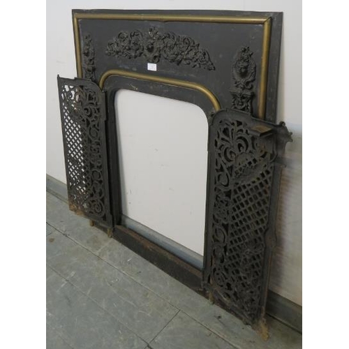 762 - An antique cast iron and brass fireplace insert, the applied decoration depicting scrolling acanthus... 