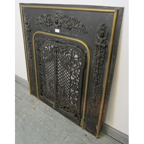 762 - An antique cast iron and brass fireplace insert, the applied decoration depicting scrolling acanthus... 