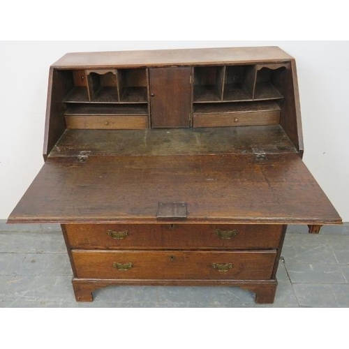 765 - An 18th century oak bureau of small proportions, the fall front opening onto a fitted interior with ... 