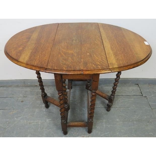 769 - An antique oak oval gateleg table of small proportions, on barley twist supports with stretchers. 
C... 