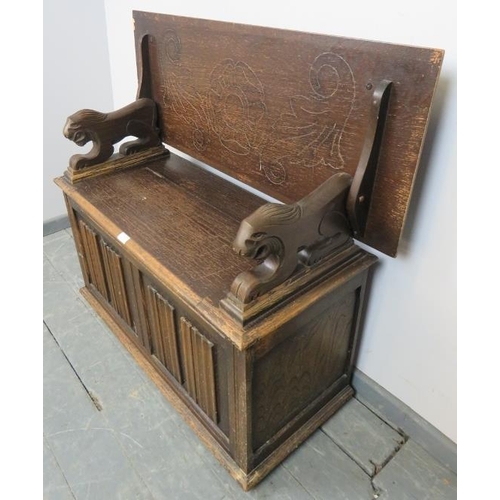 771 - An antique oak monk’s bench, with metamorphic backrest and carved arms in the form of lions, over a ... 