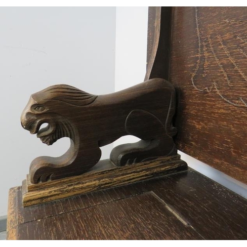 771 - An antique oak monk’s bench, with metamorphic backrest and carved arms in the form of lions, over a ... 