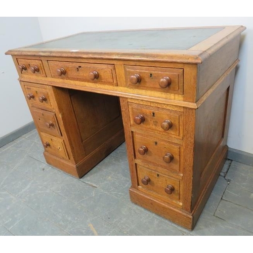 775 - A late Victorian light oak pedestal desk of small proportions, housing an array of seven graduated d... 