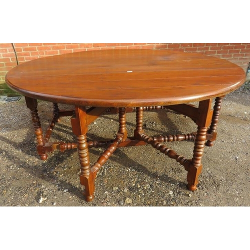 779 - A large heavy oak gate-leg table with cast iron studs, on turned and block supports united by turned... 