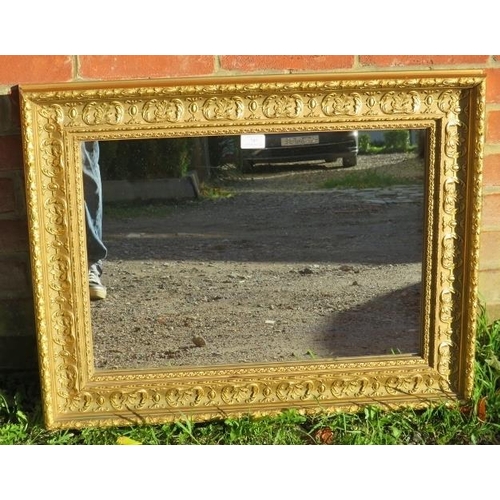 787 - An 18th century style rectangular gilt frame wall mirror in a relief moulded surround depicting acan... 