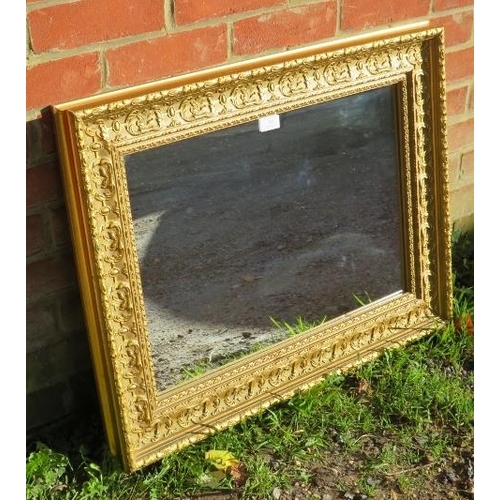 787 - An 18th century style rectangular gilt frame wall mirror in a relief moulded surround depicting acan... 