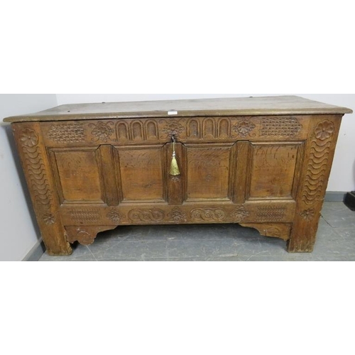 792 - A large 17th century medium oak panelled coffer, the front featuring chisel carved frieze with carve... 