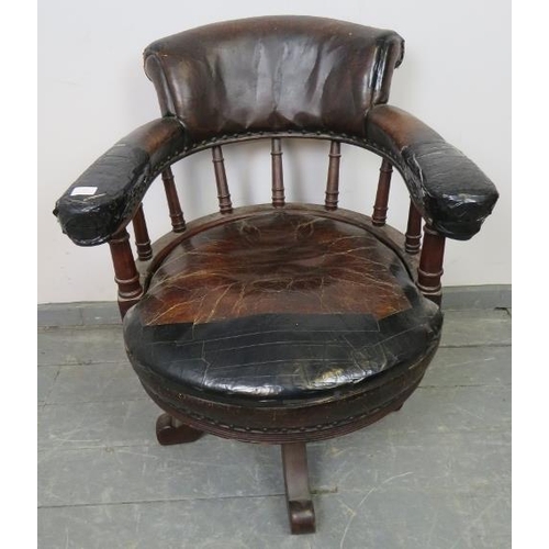 793 - An Edwardian mahogany captain’s swivel desk chair, upholstered in burgundy leather with brass studs,... 