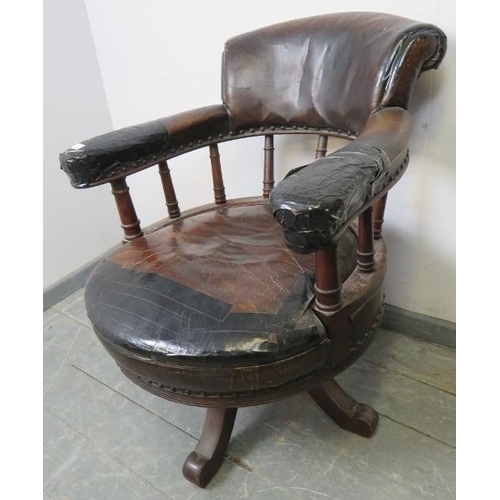 793 - An Edwardian mahogany captain’s swivel desk chair, upholstered in burgundy leather with brass studs,... 