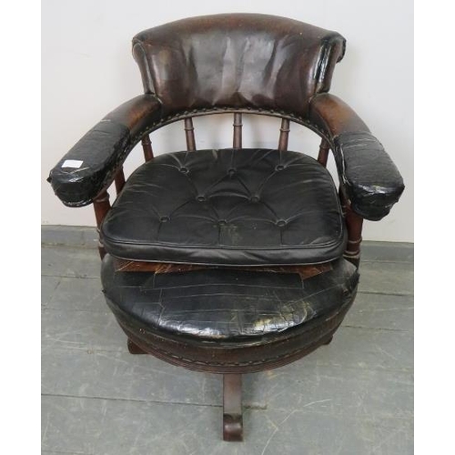 793 - An Edwardian mahogany captain’s swivel desk chair, upholstered in burgundy leather with brass studs,... 