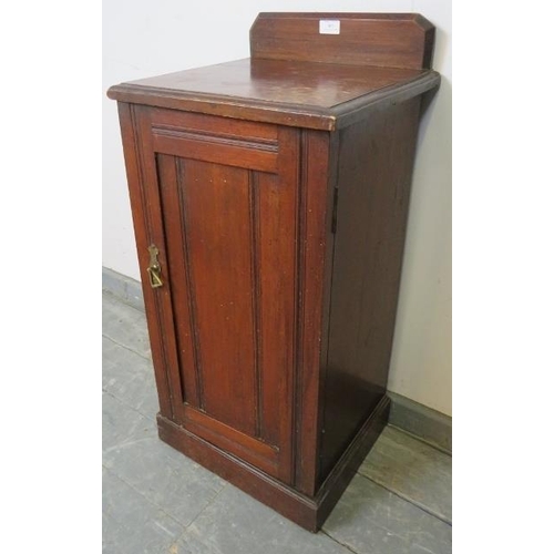 805 - An Edwardian mahogany bedside cabinet with panelled door and loose internal shelf, on a plinth base.... 