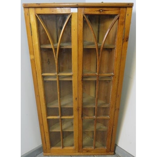 807 - An antique pitch pine hanging corner cupboard, the astral glazed doors opening onto four fitted shel... 