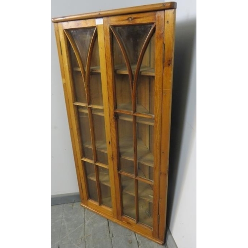 807 - An antique pitch pine hanging corner cupboard, the astral glazed doors opening onto four fitted shel... 