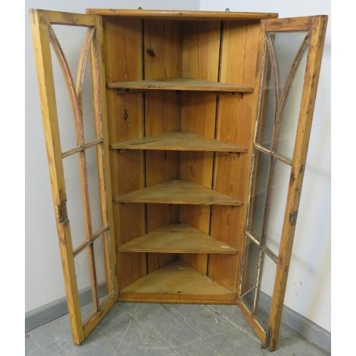 807 - An antique pitch pine hanging corner cupboard, the astral glazed doors opening onto four fitted shel... 