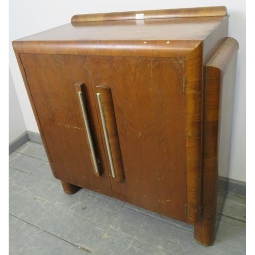 820 - An Art Deco walnut crossbanded sideboard featuring stepped sides, housing two loose shelves, on curv... 