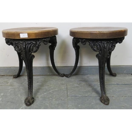 827 - A pair of small medium oak stools, on splayed cast iron supports with acanthus leaf decoration. 
Con... 