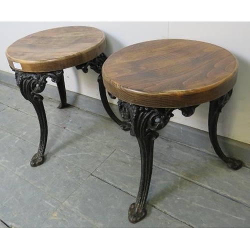 827 - A pair of small medium oak stools, on splayed cast iron supports with acanthus leaf decoration. 
Con... 