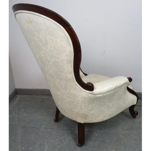 829 - A Victorian mahogany spoon back show-wood armchair with scrolled arms, reupholstered in cream button... 