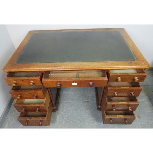 833 - A Victorian mahogany pedestal desk with green inset leather writing surface, housing nine graduated ... 