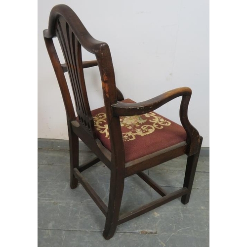 838 - A Georgian mahogany elbow chair in the manner of Hepplewhite, with carved and pierced back splat and... 