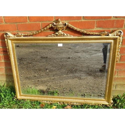 843 - A giltwood rectangular bevelled wall mirror in the Neo-Classical taste, with urn finial flanked by s... 