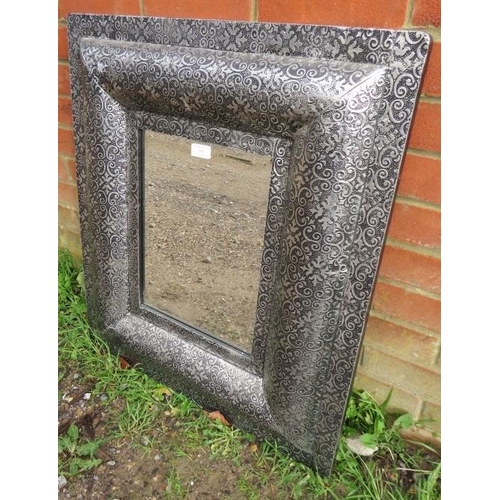 845 - A contemporary bevelled wall mirror in an intricately tooled metal surround. 
Condition report: No i... 