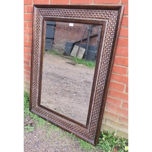 846 - A contemporary bevelled wall mirror in an intricately tooled metal surround. 
Condition report: No i... 