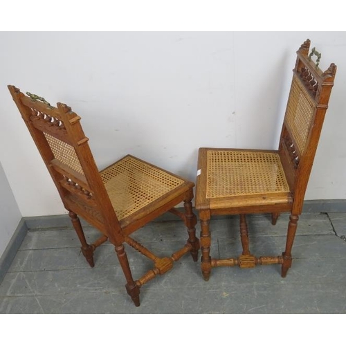 850 - A pair of Edwardian medium oak hall chairs featuring carved lion finials and turned spindles, with b... 