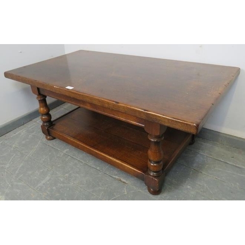 852 - A vintage heavy oak two-tier rectangular coffee table, on baluster turned supports with bun feet. 
C... 