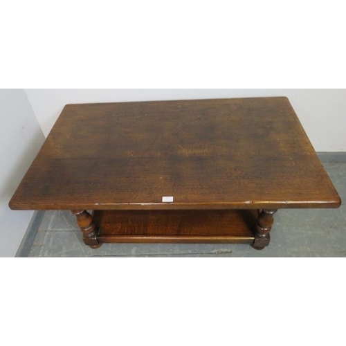 852 - A vintage heavy oak two-tier rectangular coffee table, on baluster turned supports with bun feet. 
C... 