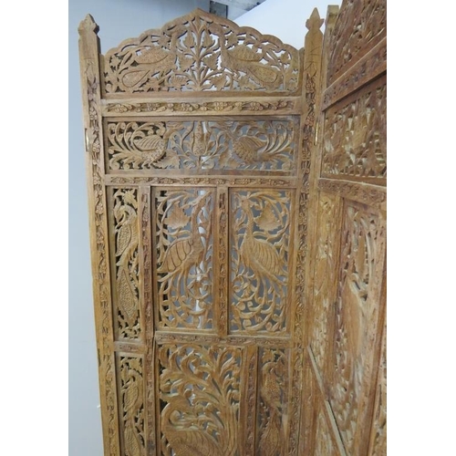 871 - A vintage hardwood Eastern four-section folding screen, with carved and pierced decoration depicting... 