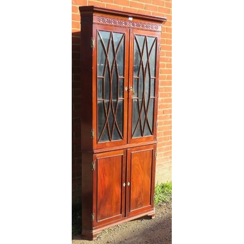 880 - A Georgian flame mahogany tall corner cupboard, with blind fret frieze above astral glazed doors ope... 