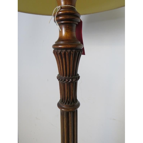 885 - A vintage mahogany standard lamp, with carved and fluted column in the Regency taste, on a tripod ba... 