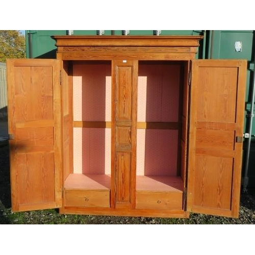 891 - An antique French pitch pine armoire, the double doors with fielded panels, opening onto a hanging r... 